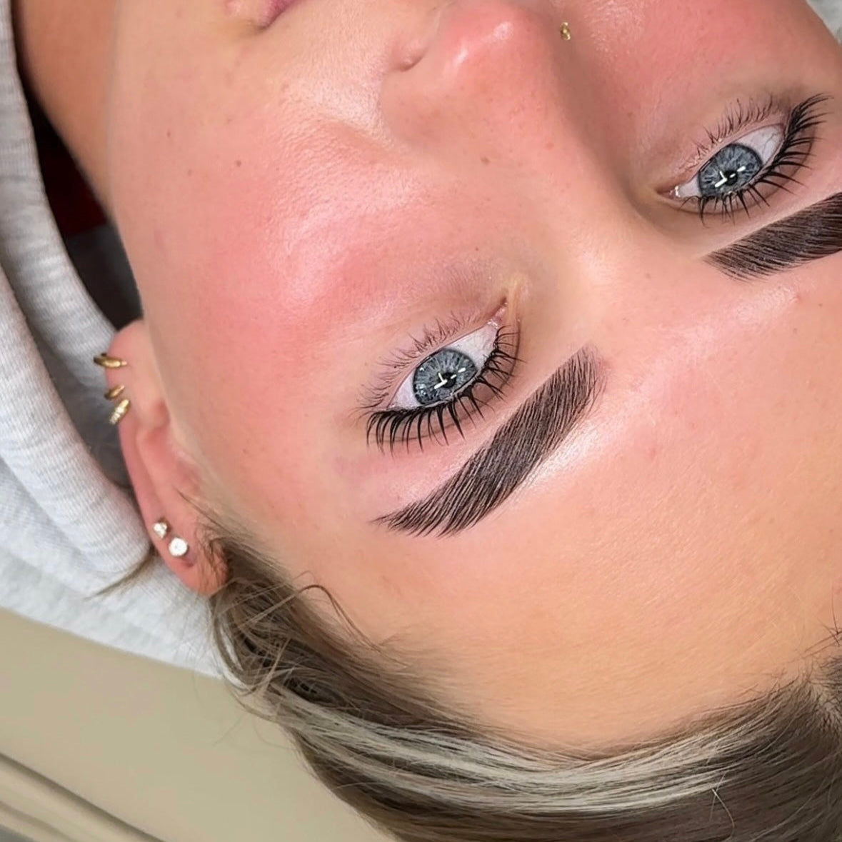 Close-up of a person with detailed makeup, including eyelashes and eyebrows.