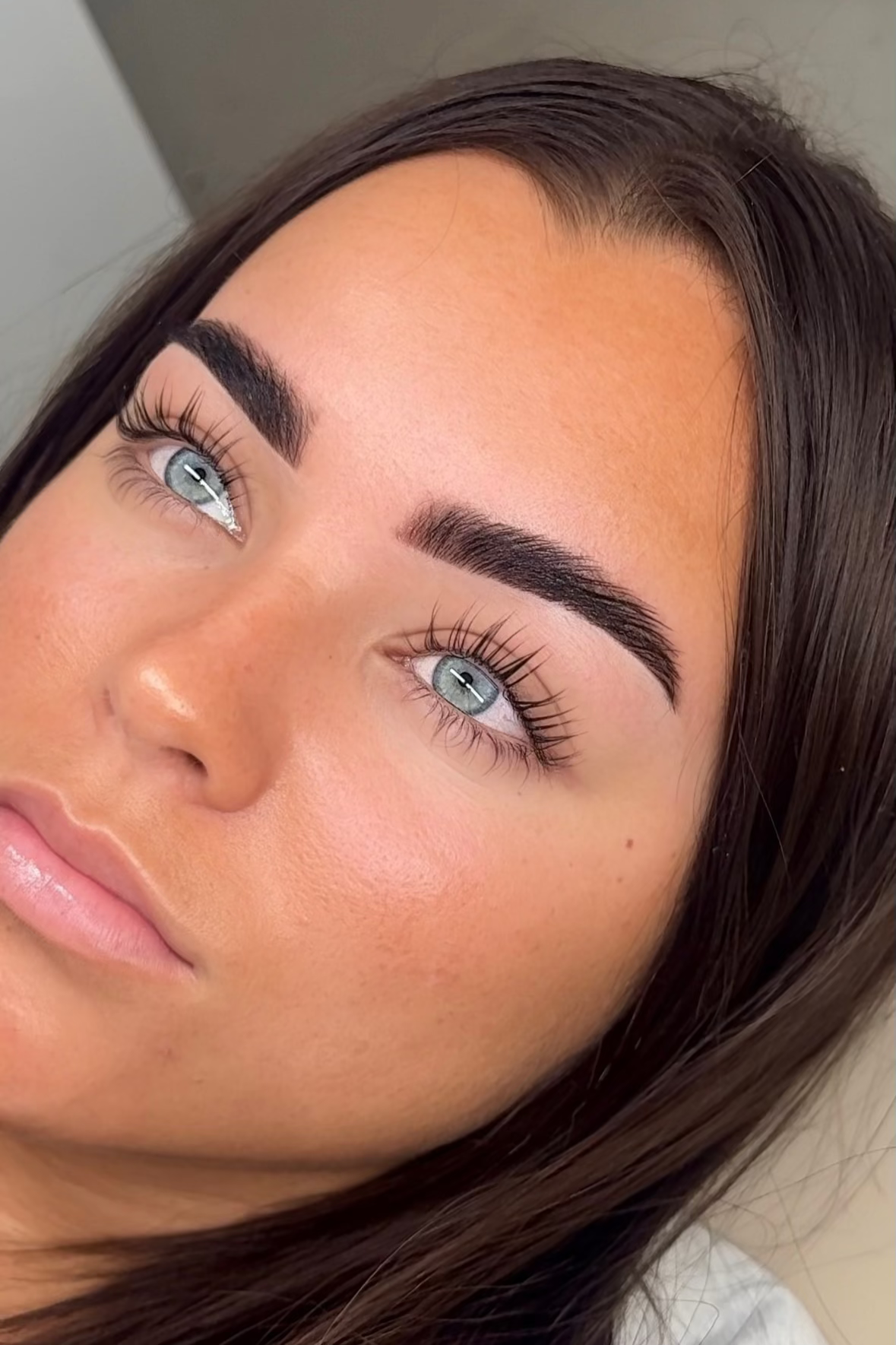 Close-up of a person with makeup, including eyelashes and eyebrows.